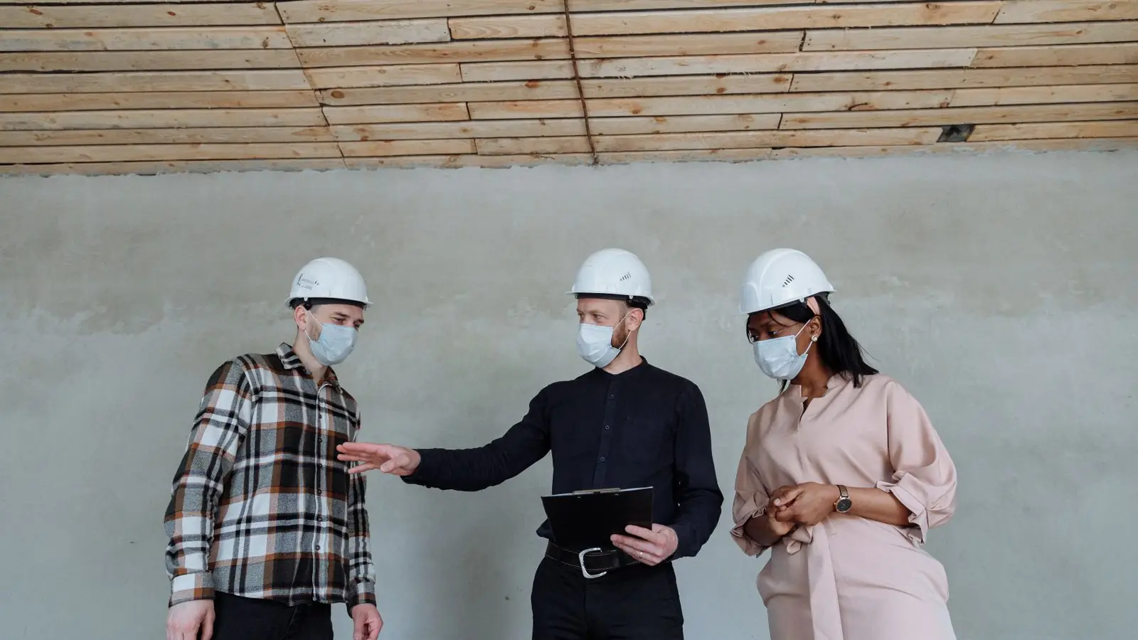 Profesionales revisando documentación con portapapeles en obra