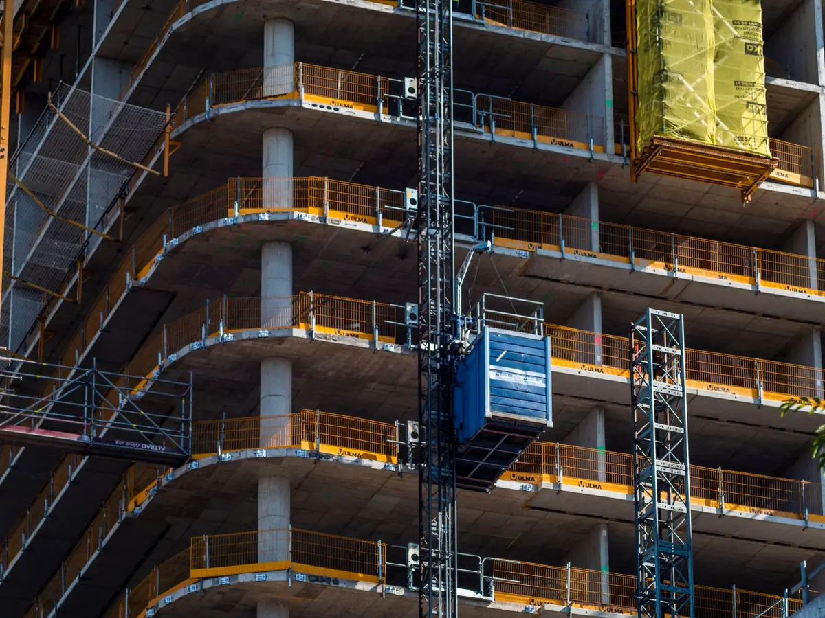 Fachada de un edificio en construcción con andamios y grúa